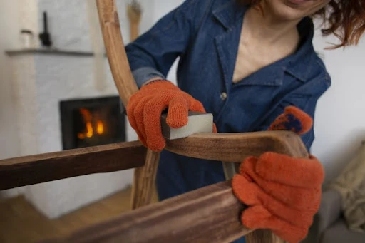 žena renovuje stoličku, ošetruje povrch
