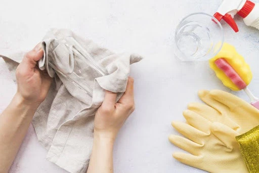 predmety na čistenie a upratovanie a ruky držiace látku