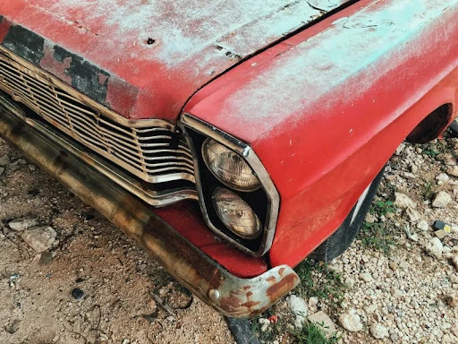 staršie červené auto napadnuté hrdzou