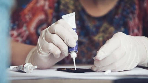človek v rukaviciach tvorí za pomoci sekundového lepidla